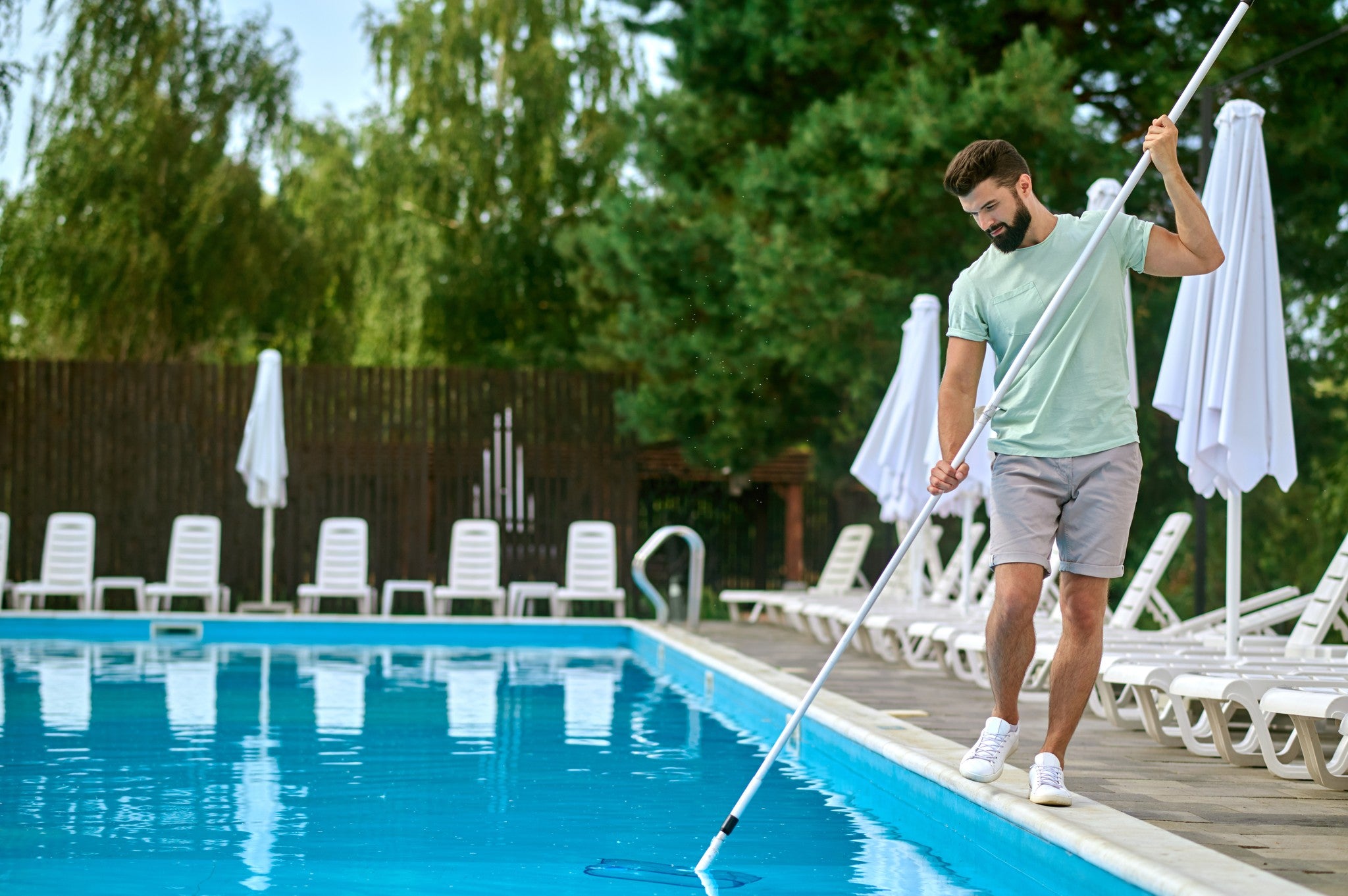 Pool technician servicing a residential swimming pool in Tampa Bay